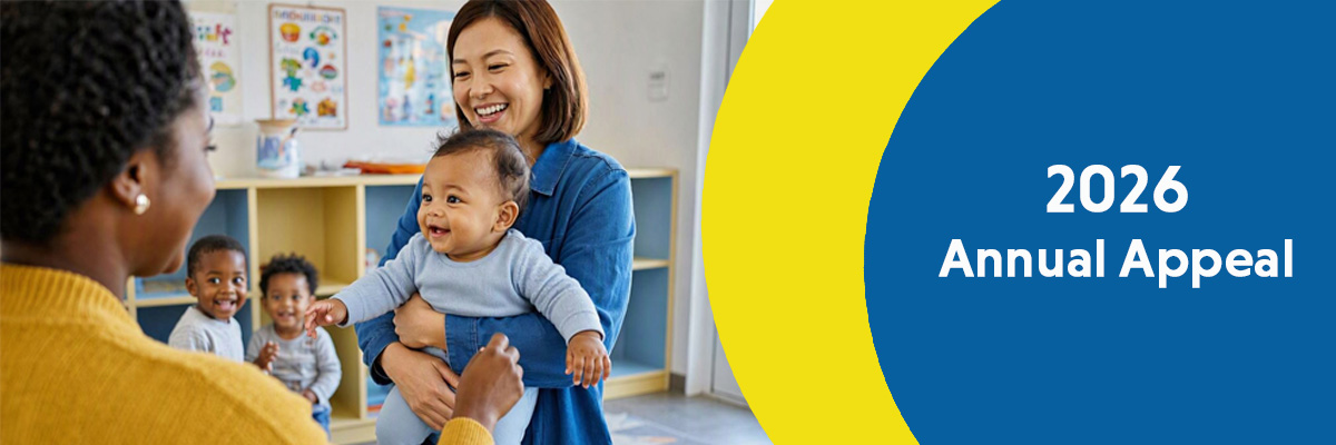 Child being held by caregiver to handoff to a child care professional